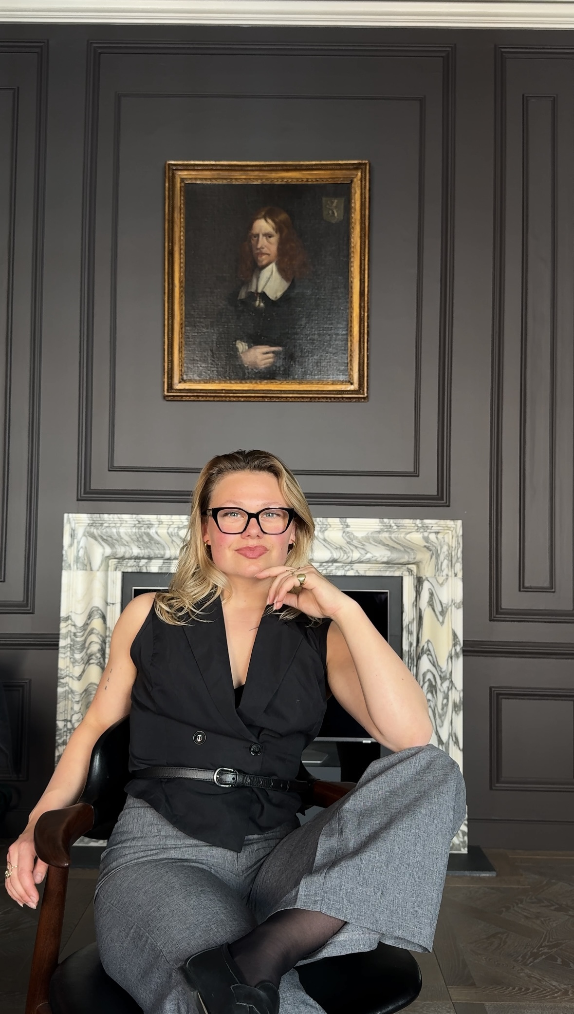 Emma Winkler Prins seated in front of a marble fireplace